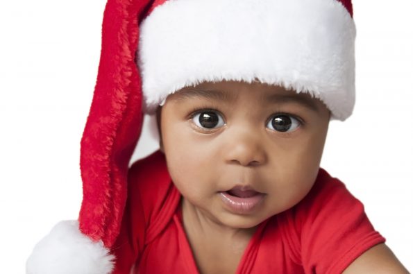 Closeup of baby wearing a christmas hat on a white background
